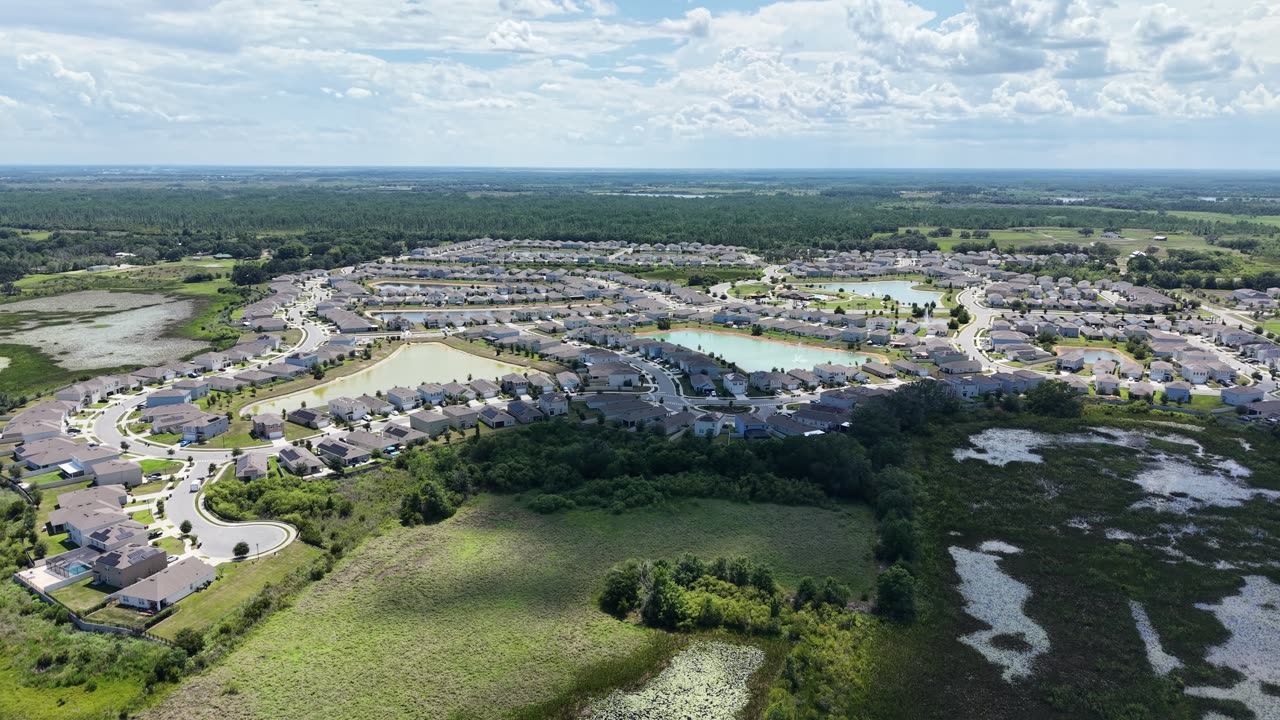 Aerial view of green spaces and natural ponds at the edge of Charles Cove